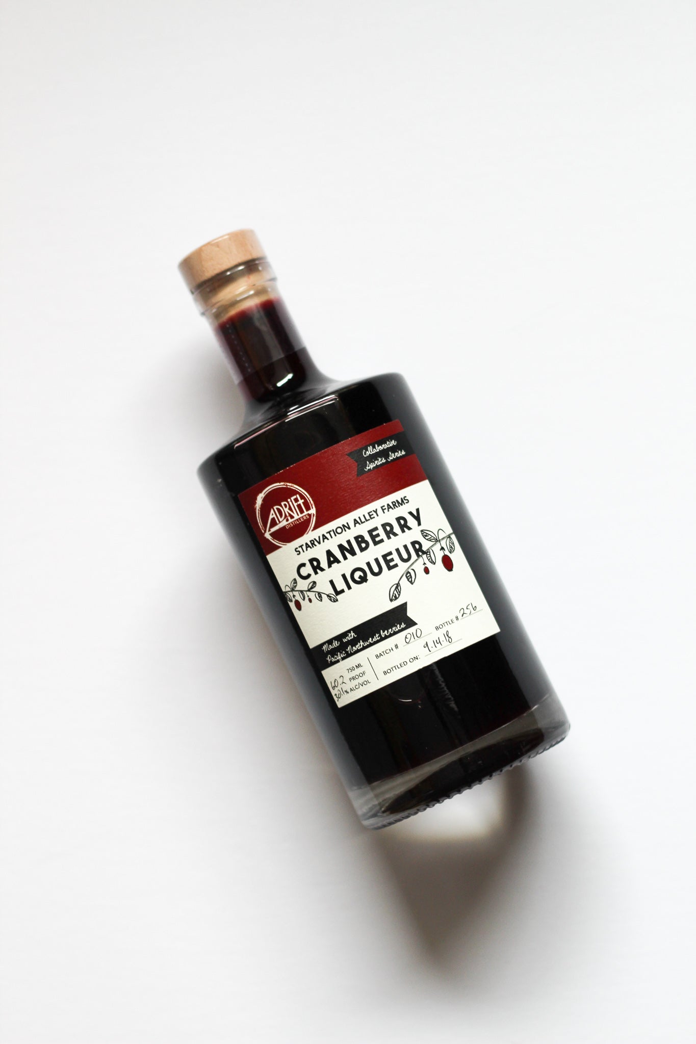 Bottle of cranberry liqueur on a white background