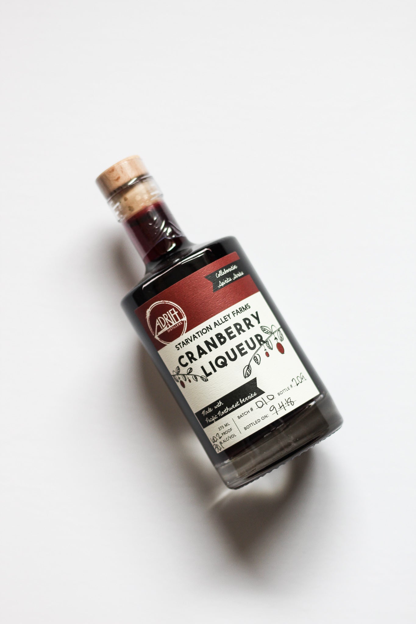 Bottle of cranberry liqueur on a white background