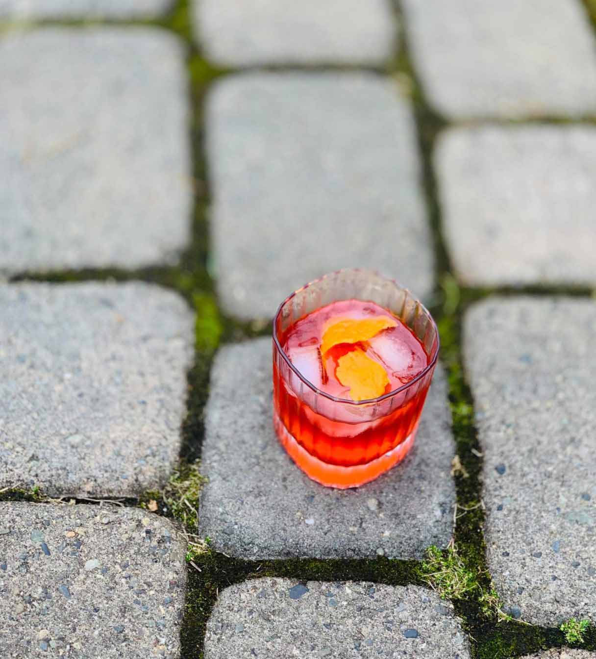 Cocktail in a glass on a stone pavement
